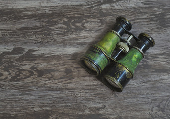 Flat lay a pair of vintage military binoculars in a grunge brown background with copy space