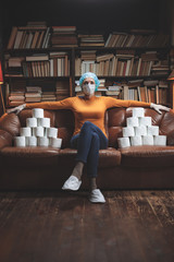 Woman with protective antiviral mask and a reserve of toilet paper waiting anxious in home...