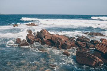 Ocean waves crash against stones in a storm