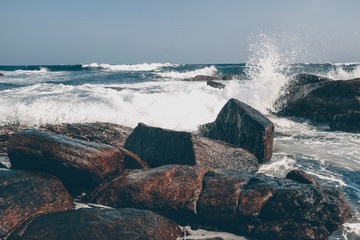 Ocean waves crash against stones in a storm