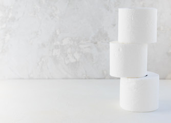Rolls of toilet paper on a light background. Horizontal orientation, copy space.