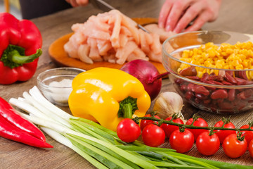 Ingredients for Burritos, chicken meat, corn, tomatoes and peppers on wooden background. Top view