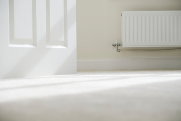 New white radiator white on pale wall house interior