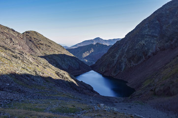 Fototapeta na wymiar Estany Negre lake in Pyrenees mountains, trekking trail in Andorra to Pico de Coma Pedrosa summit