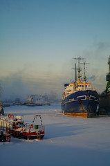  Ships and cranes in cargo port of St. Petersburg in winter time, covered by ice and snow
