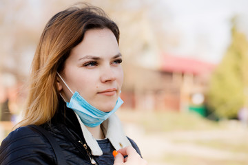 Young beautiful woman breathes fresh air in a mask on her face.