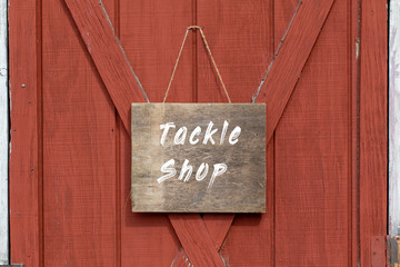 tackle shop  wooden sign, old weathered wooden sign on a barn door 