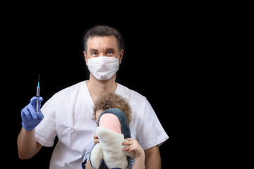 A doctor with medical mask and gloves patiently explain to the child about the vaccine he needs to...