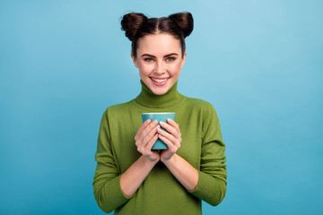 Photo of pretty attractive charming lady teenager hold hot beverage cup tea coffee enjoy morning wear warm green turtleneck pullover isolated blue color background