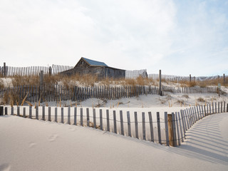 Long late afternoon shadows highlight the thin wooden slats of the storm fencing found in New Jersy Island Beach State Park to protect the sand dunes from wind wave and human erosion