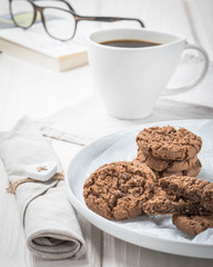 cup of coffee, chocolate candies and cookies on table