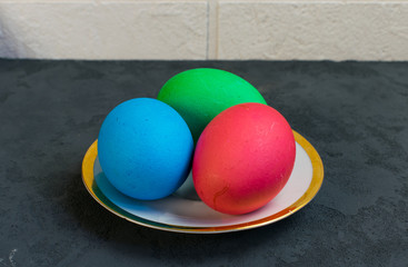 Colored eggs in a plate on the table, Easter is coming
