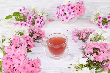 Beautiful floral greeting card, summer abstract background, spring and comfort concept. Colorful flowers and tea, home office top view, flat lay, selective focus