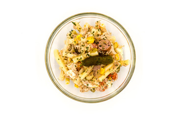 Pasta salad dish with corn, tuna and a pickle