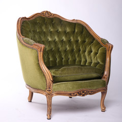 Luxurious, antique green armchair on a white, isolated background. Old, palace furniture. Side view.
