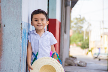 An adorable child with a hat on the street 