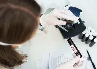 Scientist in laboratory working with microscope. Covid-19 concept.