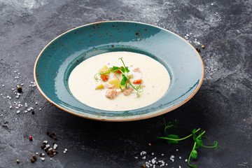 A bowl of creamy soup with salmon. 