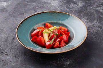 Salad with tomatoes and cheese on stone table