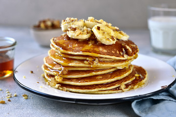 Homemade delicious banana pancakes with walnuts and maple syrup.