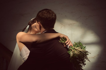bride and groom kiss with a bouquet in their hands