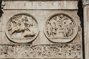 The Arch of Constantine is located next to the Colosseum in Rome. Via di San Gregorio street. The bas-reliefs of the arch were removed from other architectural structures. Three-span gate.