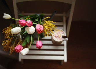 March 8,Easter,Mother's day concept /tulips in the vase,cup of coffee with marshmallows,open book ,glasses