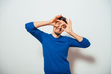 man looking through hands, making binoculars