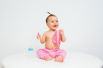 Healthy baby girl smiles and holds a water bottle