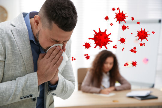 Sick man sneezing in office. Dangerous virus