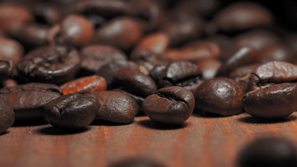 Closeup of Roasted brown coffee beans lye on the table, front view.