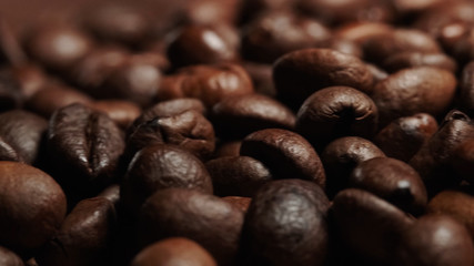 Closeup of Roasted brown coffee beans lye on the table, front view.