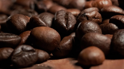 Naklejka premium Closeup of Roasted brown coffee beans lye on the table, front view.