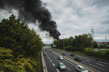 Photo of a fire in next to a motorway in Stegne, Ljubljana, Slovenia. Dark plume of smoke is visble...