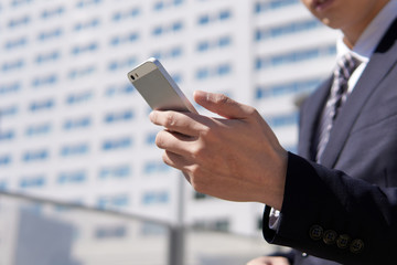 スマートフォンを操作する日本人男性ビジネスマン