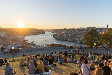 Group of people enjoying sunset over Porto from a hill