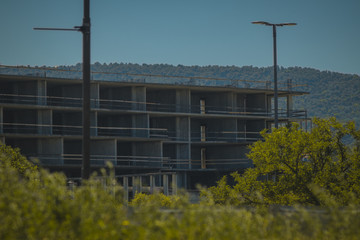 Obraz premium An abandoned construction site of a commercial building is waiting between the trees. Empty construction site, good for failed plans in construction photo