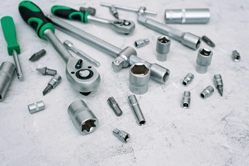 Car maintenance and repair concept. Tool set made of stainless chrome steel on a gray industrial background. screwdriver, wrench, spanner. Copy space. Flat lay.