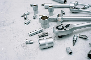 Car maintenance and repair concept. Tool set made of stainless chrome steel on a gray industrial background. screwdriver, wrench, spanner. Copy space. Flat lay.