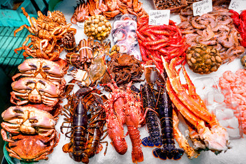 Fresh crabs, lobsters. langustas and shrimps on ice in the Barcelona fish market