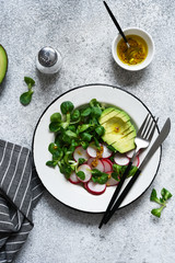 Corn salad with avocado and radish with mustard and honey sauce. Vitamin salad, top view.