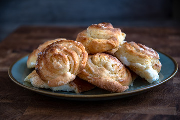 Homemade round cheesecakes, cottage cheese in the dough, in a plate on a wooden table in the kitchen.