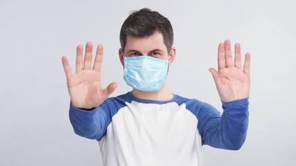 man distancing from camera wearing protection mask on face isolated on grey