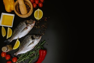 Fish seafood dorado cooking, raw food on black background, nutrition.