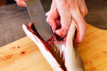 Cutting raw fish tuna food, red seafood.