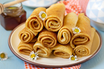 Sweet thin pancakes crepes served with honey