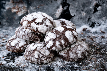 Freshly backed sweet chocolate cookies at baking sheet. Cookies sprinkled with powdered sugar