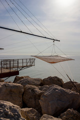 Shore-operated lift net at the Port of Senigallia, Province of Ancona, Marche Region, Italy, glittering Adriatic Sea water surface in the background, Chinese fishing net