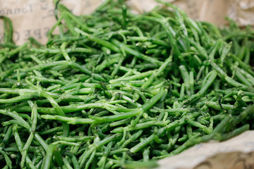A closeup view of a basket of sea beans, on display at a local grocery store.