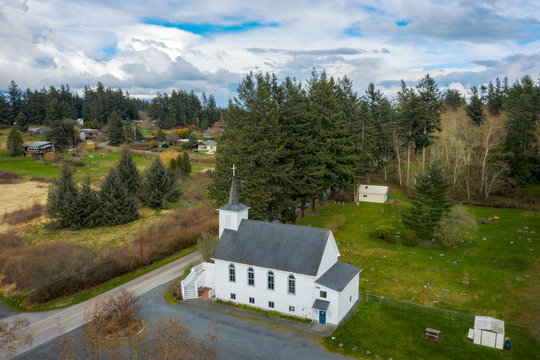 Aerial View of a Little White Church in the San Juan Islands of the Pacific Northwest. An historic church and graveyard located in western Washington state.